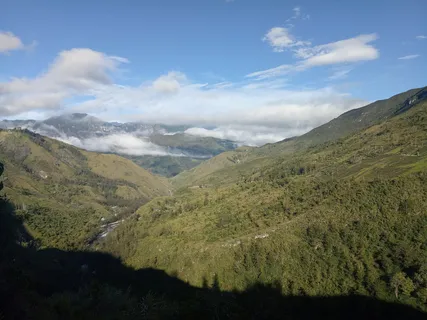 Lembah pegunungan Papua dengan lahan hijau dan perbukitan.